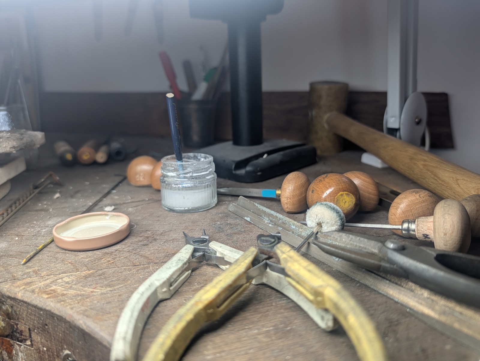 Pinces, maillets et outils de bijoutier sur l'établi de l'atelier
