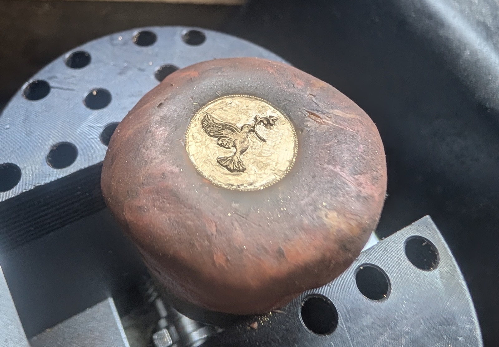 Médaille en or gravée à la main d'une colombe, sur sa boule de graveur